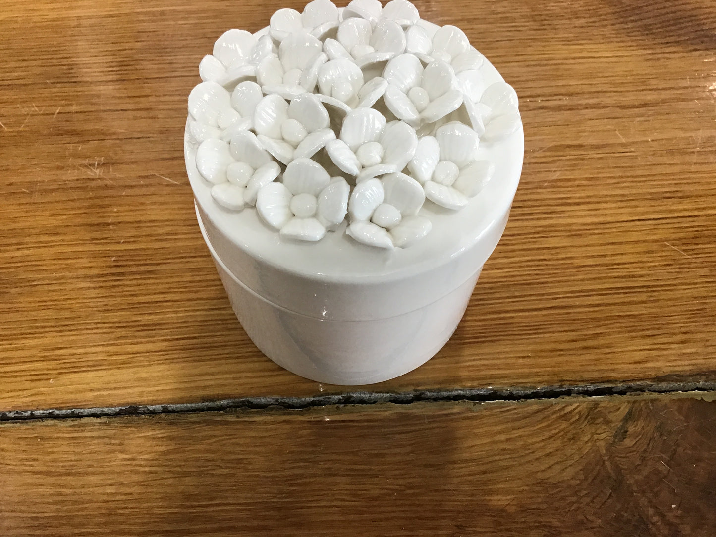 White small ceramic box with lid and small flowers on top